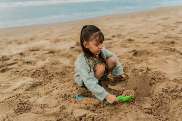 istock Child girl making sandcastle at beach 2156170417