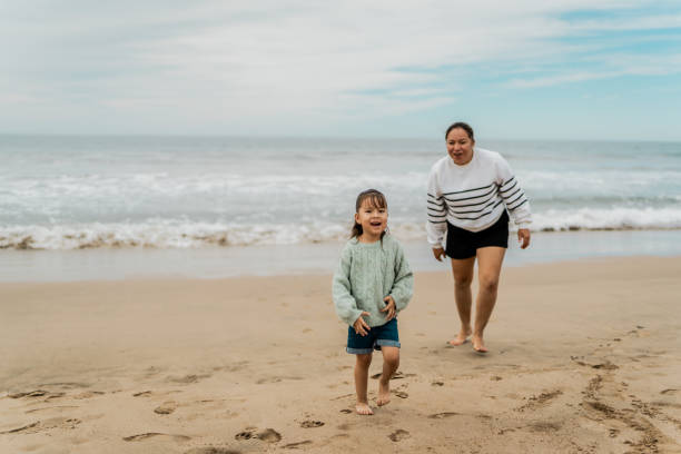 istock Mother and daughter running at beach 2156170435
