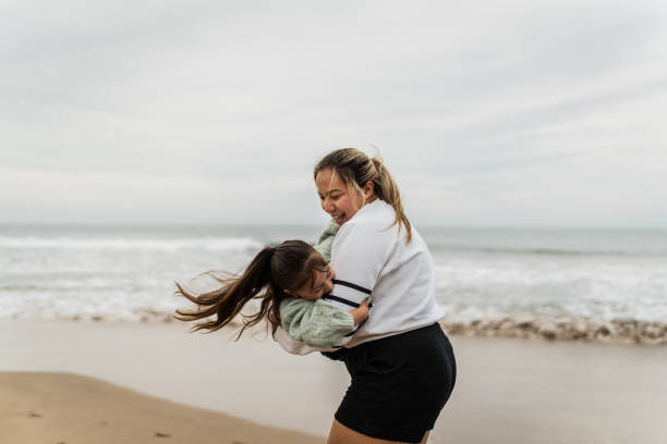 istock Mother playing spin with daughter at beach 2156170527
