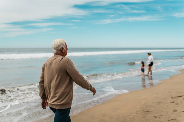 istock Senior man walking on the beach 2156170646