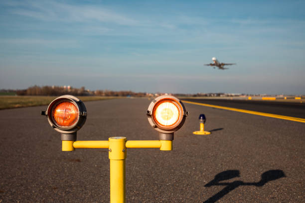 Traffic at airport on sunny day. Close-up of safety lights warning of airport runway ahead.