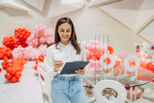 istock A cheerful female party organizer crosses tasks off her to-do list while decorating a restaurant for a party 2156170848
