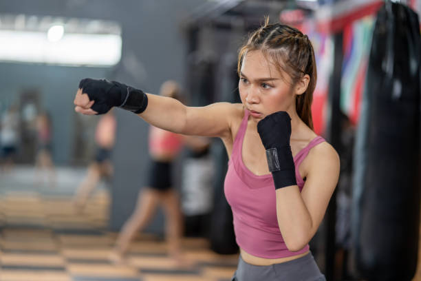 istock Young female boxer. Asian female boxer training and practicing Muay Thai at the gym. 2156171776