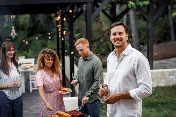 istock Young casually clothed man posing for a shot while having barbeque with his friends 2156172530