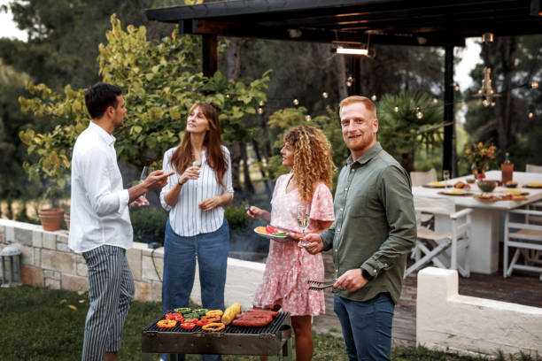 istock Young casually clothed man posing for a shot while having barbeque with his friends 2156172534