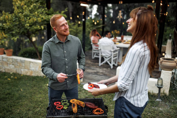 istock Casually clothed couple preparing barbeque for their friends at the backyard 2156172572