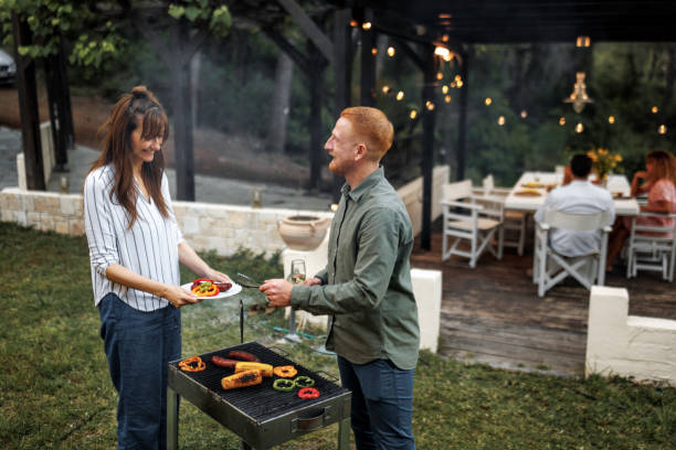 istock Casually clothed couple preparing barbeque for their friends at the backyard 2156172577