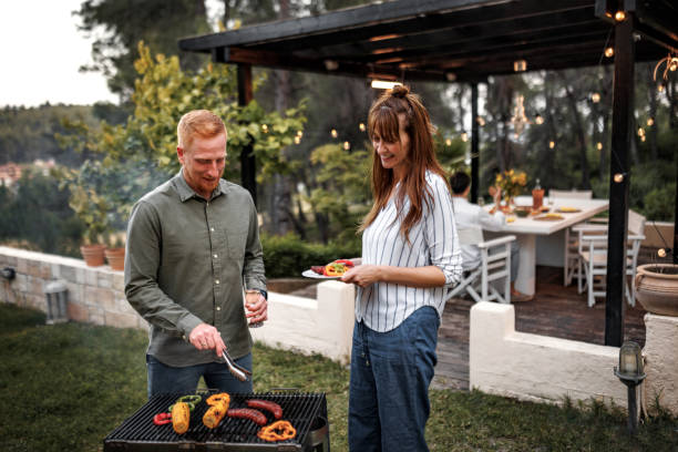 istock Casually clothed couple preparing barbeque for their friends at the backyard 2156172587