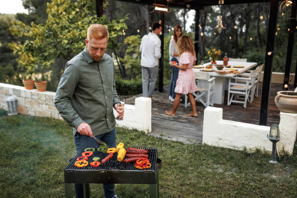istock Casually clothed young man making barbeque for dinner party at his back yard 2156172605
