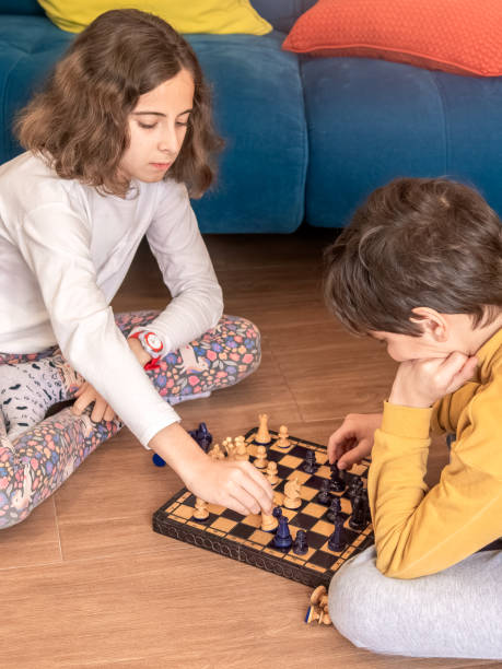 istock Children Engaged in Chess Game at Home 2156173600