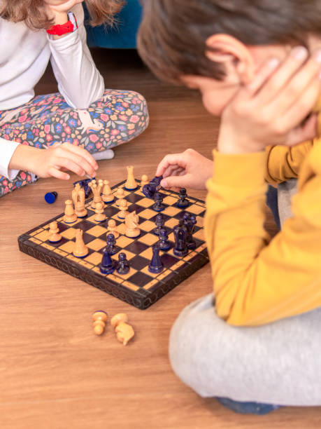 istock Children Engaged in Chess Game at Home 2156173602