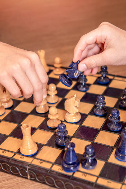 istock Children's hand moving chess piece. Selective focus 2156173615