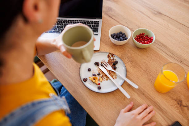 istock Female freelancer finishing up her breakfast while working from home 2156173836