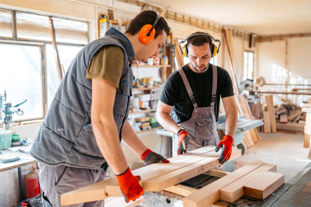 istock Two Young Male Carpenters Working With Wood In The Workshop 2156174783