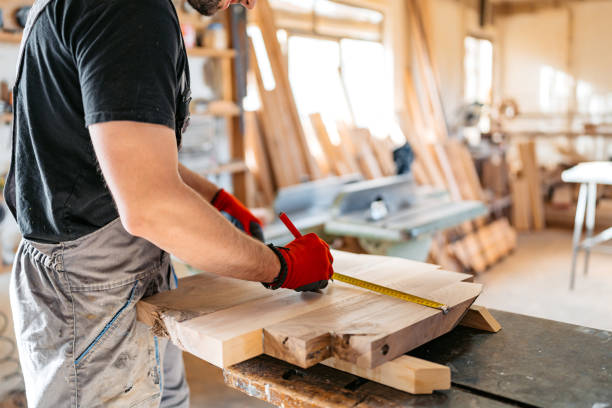 istock Young Male Carpenter Measuring Wood In His Workshop 2156174820