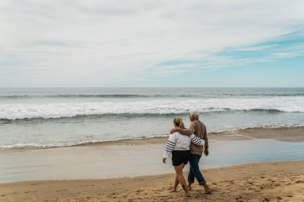 istock Father talking to daughter and walking on the beach 2156176844