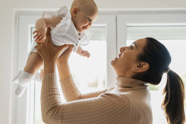 istock Woman playing with baby in daylight 2156179270