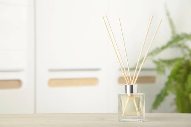 istock Aroma sticks in glass bottle. Aroma diffuser on table in room 2156179558
