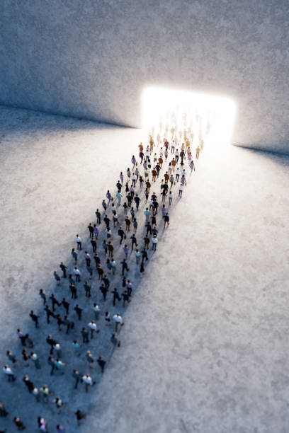 istock Crowd of people walking towards bright light gate in large space 2156179903