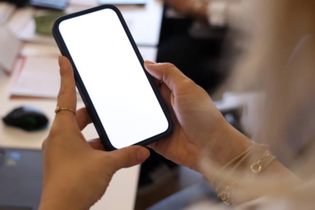 istock Young woman holding mobile phone with white empty blank screen 2156180200