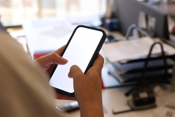 istock Young woman holding mobile phone with white empty blank screen 2156180254