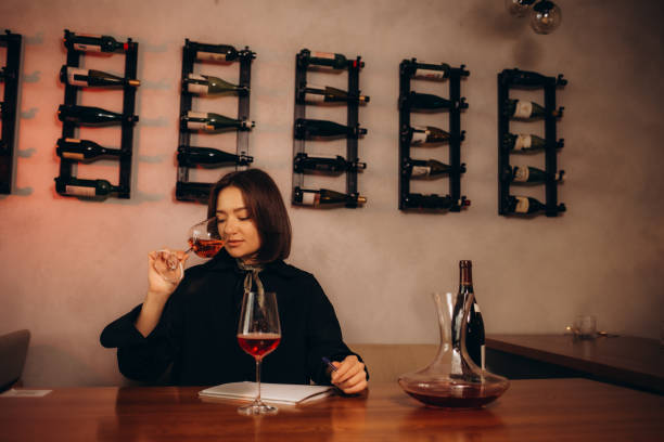 istock Brunette woman sommelier tasting smelling wine and writing notes. 2156181909