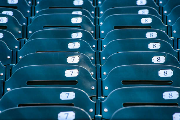 Green plastic stadium worn out chair seats in rows