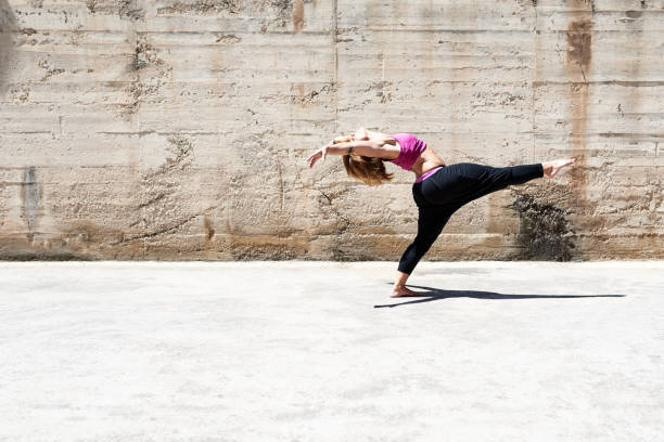 istock Active woman dancing against shabby wall on sunny day 2156185473