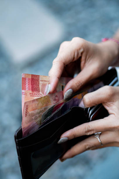 istock Person holding wallet with Indonesian Rupiah banknotes 2156193680