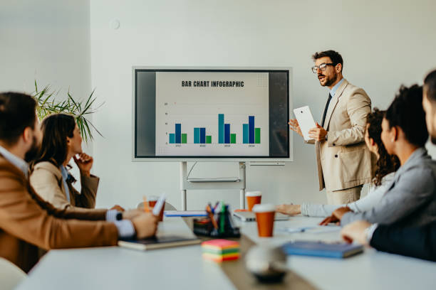 istock Businessman presenting bar chart infographic during modern meeting 2156197576