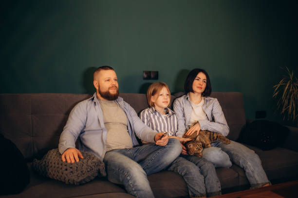 istock Family watching movie on sofa at night 2156200594