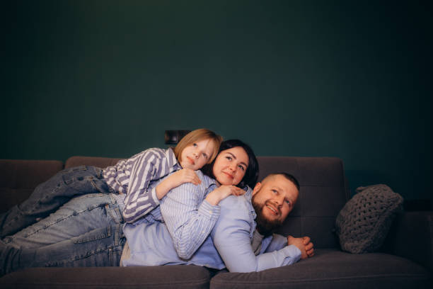 istock Dad, mom and daughter relaxing on the couch at home 2156200608