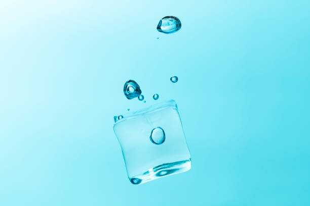Close up macro color image depicting a colorful water drop splashing into a body of water, with ripples. Room for copy space.