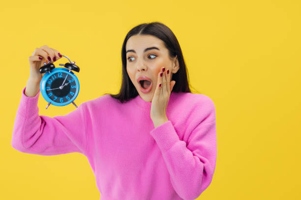 istock stressed woman hold alarm clock missing time and being late for important meeting or work. 2156203912