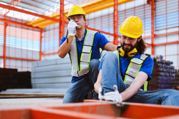 istock Caucasian foreman using walkie-talkie to contact safety team for help while co-worker had a steel frame crush his leg at industrial factory. 2156204088