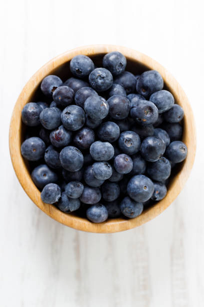 istock Ripe organic blueberries on white wooden table background. Selective focus. 2156207159