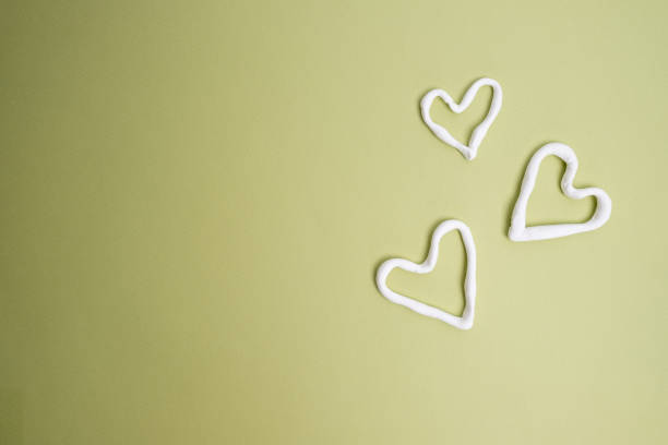 istock White hearts on a colored background. View from above. Copy space. concept postcard, valentine's day, birthday 2156207590