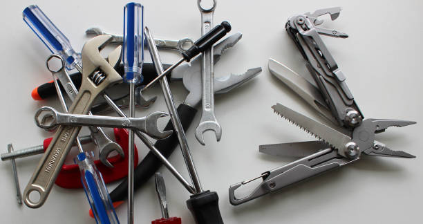 istock Folding utility knife with blades spread out against a pile of unnecessary tools vertical stock photo 2156208664