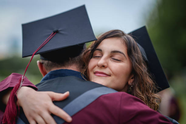 istock Group of college students  embracing on graduation day. 2156210499