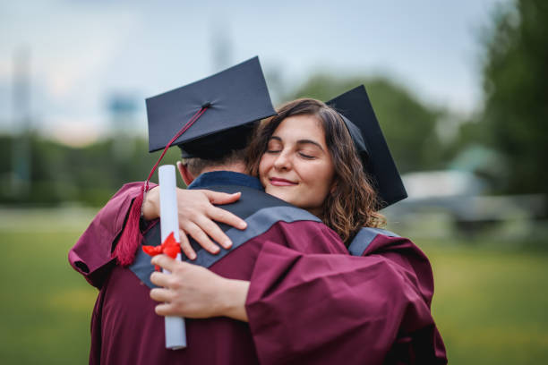istock Group of college students  embracing on graduation day. 2156210553