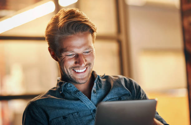 istock Night, business and man with a tablet, typing and smile with connection, project and communication. Person, evening and creative employee with technology, email notification and internet for research 2156211362
