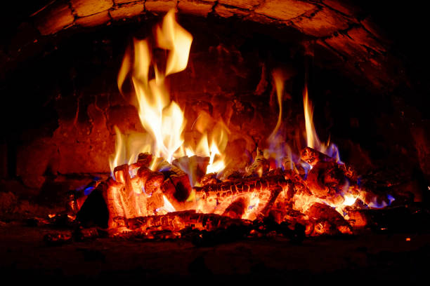 istock Burning logs are surrounded by vibrant, moving flames of fire. 2156212242