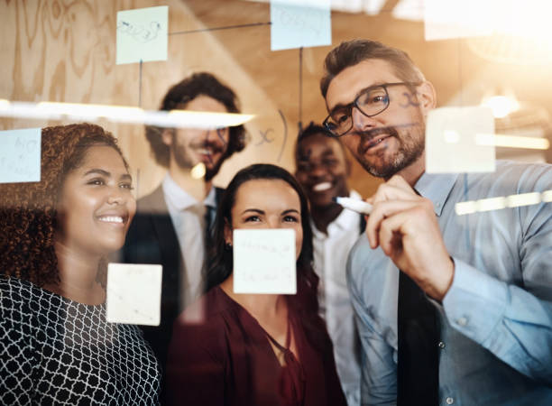 istock Business people, glass and brainstorming with teamwork, writing and planning with cooperation, share ideas and project. Group, employees or agency with transparent board, collaboration and creativity 2156212466