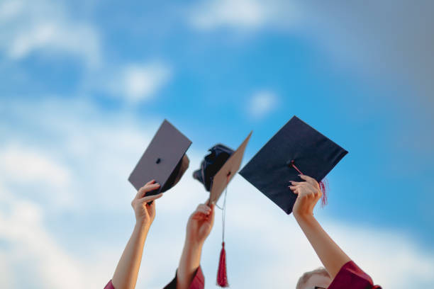 College graduates throwing graduation hats in the air Part of a Series: group of college students graduation day. graduation throwing cap stock pictures, royalty-free photos & images