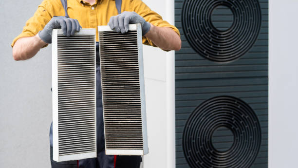 istock Worker in gloves holding two dirty air filters from a home ventilation system. 2156216769