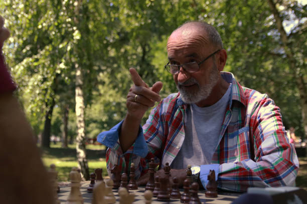 istock Senior man play chess in nature 2156219651