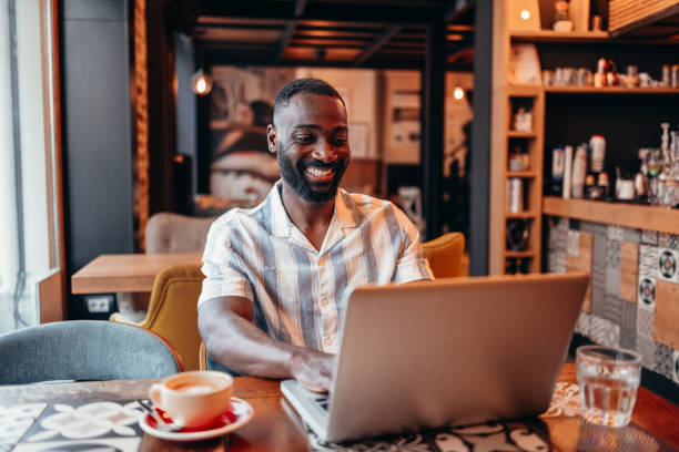 istock Man sitting in coffee shop and using laptop 2156220632