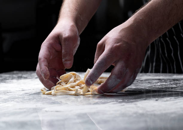 istock Cooking pasta spaghetti dough with flour on a dark black background with spatial area. Food banner, large resolution. 2156222816