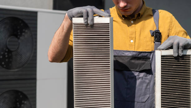 istock Plumber holding heavily clogged air filters from a home air conditioning system. 2156225514
