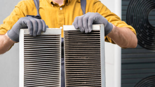 istock Worker holding two dirty air filters from a home ventilation system. 2156225547